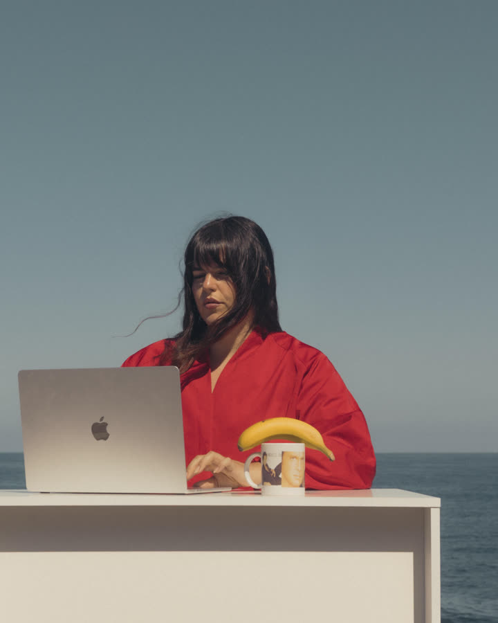 Ana Villar trabajando con un portátil frente al mar